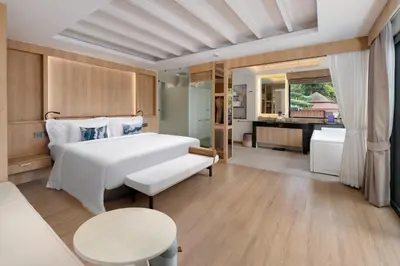 a bedroom with a white bed and a bathroom at Centara Villas Phi Phi Island in Phi Phi Don