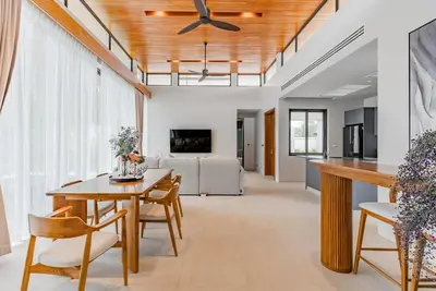 a dining room and living room with a ceiling fan at Botanica Modern Loft by Villacarte in Ban Pak Lak