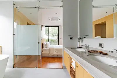 a bathroom with two sinks and a mirror at Botanica Modern Loft by Villacarte in Ban Pak Lak