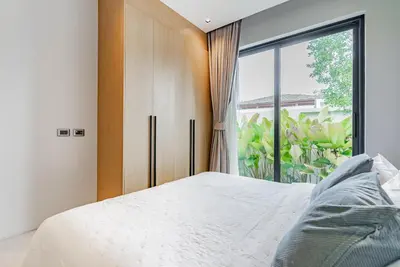 a bedroom with a bed and a large window at Botanica Modern Loft by Villacarte in Ban Pak Lak
