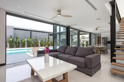 a living room with a couch and a table at New & Modern, Loft Style 4BR Villa Sunset Garden 3, 12m Salt Pool, just 10min drive Naiharn Beach in Rawai Beach