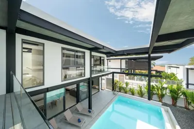 an apartment with a balcony with a swimming pool at New & Modern, Loft Style 4BR Villa Sunset Garden 3, 12m Salt Pool, just 10min drive Naiharn Beach in Rawai Beach