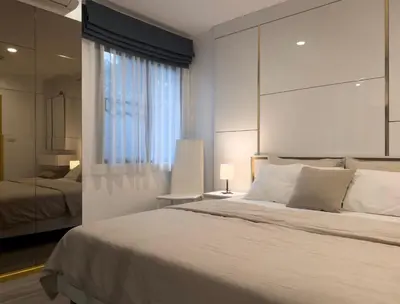 a bedroom with a large white bed and a mirror at The Title Residences Apartment 7 min walk to Nai Yang Beach in Nai Yang Beach