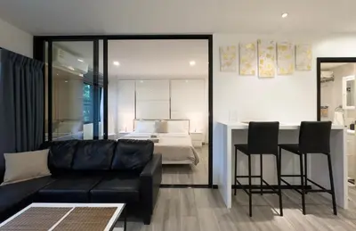 a living room with a couch and a bedroom at The Title Residences Apartment 7 min walk to Nai Yang Beach in Nai Yang Beach