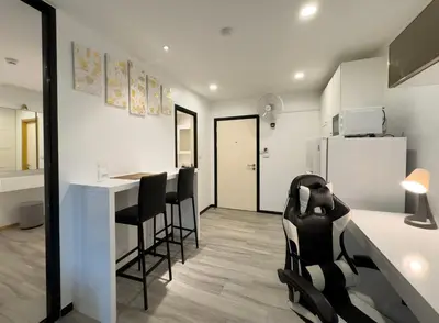 a kitchen with black chairs and a counter with a refrigerator at The Title Residences Apartment 7 min walk to Nai Yang Beach in Nai Yang Beach