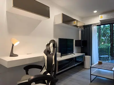 a living room with a chair and a television at The Title Residences Apartment 7 min walk to Nai Yang Beach in Nai Yang Beach
