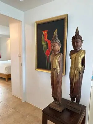 two statues on a table in a room with a painting at Ocean View Residences! in Phuket Town