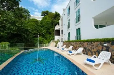 a swimming pool with lounge chairs and a building at Ocean View Residences! in Phuket Town