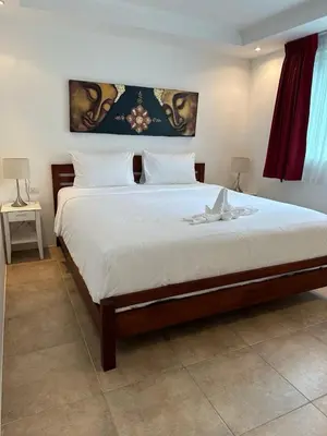 a bedroom with a large bed with white sheets at Ocean View Residences! in Phuket Town