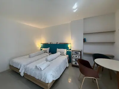a bedroom with two beds and a table and chairs at Five Loaves Beds Patong in Patong Beach