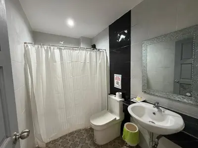 a bathroom with a white toilet and a sink at Five Loaves Beds Patong in Patong Beach