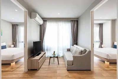a living room with a couch and a bed and a tv at Diamond Resort in Bang Tao Beach