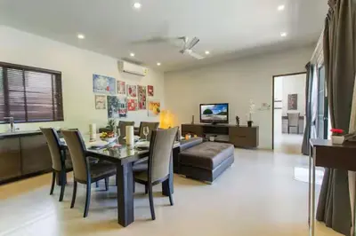 a dining room and living room with a table and chairs at Вилла Boutique Pool Villa с 3 спальнями in Ban Saiyuan (1)