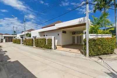 a white house with hedges in front of a street at Вилла Boutique Pool Villa с 3 спальнями in Ban Saiyuan (1)