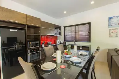 a dining room and kitchen with a table and chairs at Вилла Boutique Pool Villa с 3 спальнями in Ban Saiyuan (1)