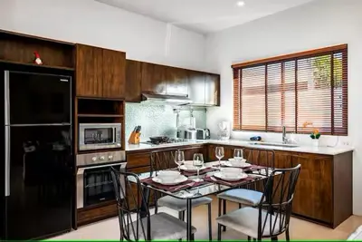 a kitchen with a table and chairs in it at West facing 3br Boutique Pool Villa in Phuket Town