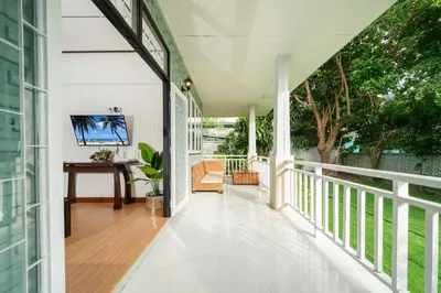 a white porch with a table and a desk at Rawai Cottage House in Rawai Beach
