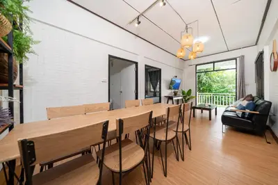 a dining room with a long table and chairs at Rawai Cottage House in Rawai Beach