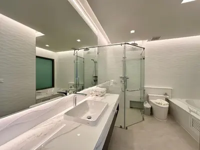 a white bathroom with a sink and a shower at The Regent Phuket Bangtao Beach in Bang Tao Beach
