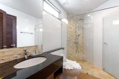 a bathroom with a sink and a toilet and a window at The Regent Phuket Bangtao Beach in Bang Tao Beach