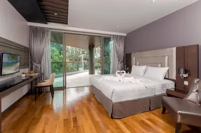 a bedroom with a large white bed and a television at The Regent Phuket Bangtao Beach in Bang Tao Beach