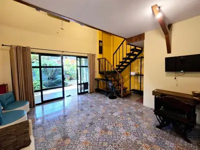 a living room with a couch and a television and a staircase at Baibon 4 Homestay Thalang Phuke in Thalang