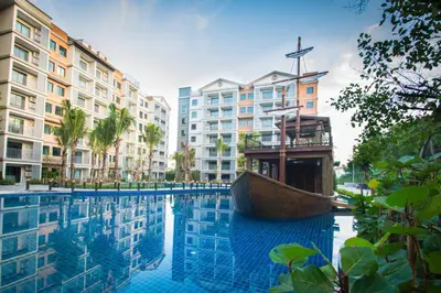 a swimming pool with a boat in front of buildings at Title Residencies Naiyang 2 Bedrooms PoolAccess in Nai Yang Beach