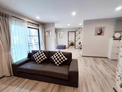 a living room with a couch and a large window at Title Residencies Naiyang 2 Bedrooms PoolAccess in Nai Yang Beach