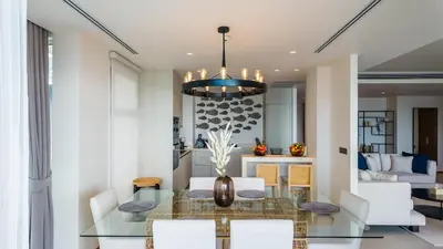 a dining room with a glass table and white chairs at Laguna Seaview Penthouse with Rooftop Pool 50 m to Bang Tao Beach in Bang Tao Beach