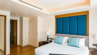 a bedroom with a large bed with blue curtains at Laguna Seaview Penthouse with Rooftop Pool 50 m to Bang Tao Beach in Bang Tao Beach