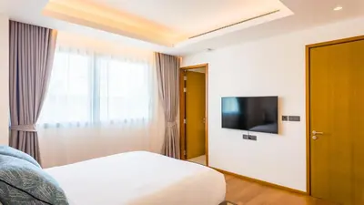 a hotel room with a bed and a television at Laguna Seaview Penthouse with Rooftop Pool 50 m to Bang Tao Beach in Bang Tao Beach