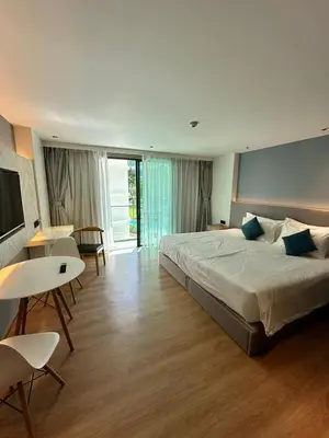 a bedroom with a large bed and a table and chairs at HomeAwayFromHome in Phuket Town