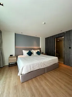 a bedroom with a large white bed with blue pillows at HomeAwayFromHome in Phuket Town