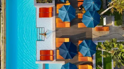 an overhead view of a pool with chairs and umbrellas at Bandara Beach Resort, Phuket in Panwa Beach
