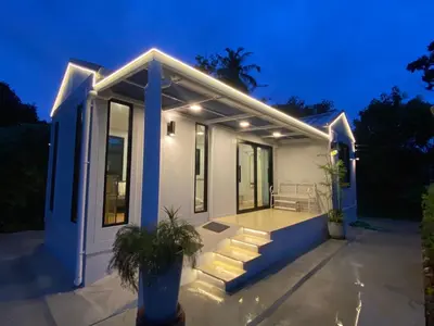 a small white house with a porch at night at Little Sweet Home in Phuket Town