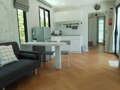 a kitchen and living room with a table and a couch at Little Sweet Home in Phuket Town