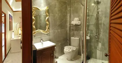 a bathroom with a shower and a toilet and a sink at Baan Sung Apartments in Kamala Beach