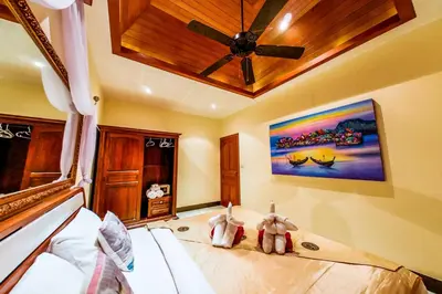 a bedroom with two teddy bears sitting on a bed at Baan Sung Apartments in Kamala Beach