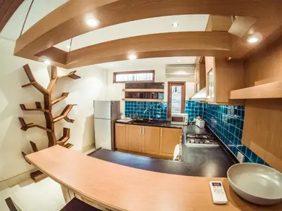 a kitchen with a wooden table in a room at Baan Sung Apartments in Kamala Beach