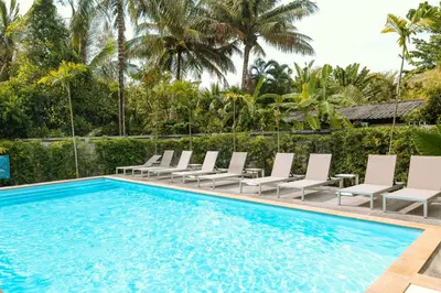 a pool with chaise lounge chairs and a resort at Seaside Naithon Phuket - Newly Opened in Nai Thon Beach