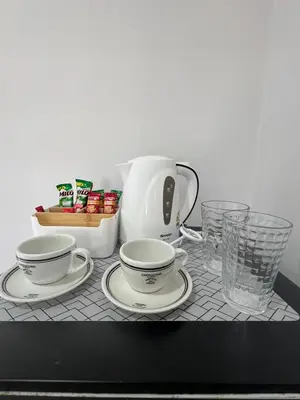 a table with two plates and a tea pot and glasses at Nub-Nueng place นับหนึ่ง เพลส in Ban Bo Han