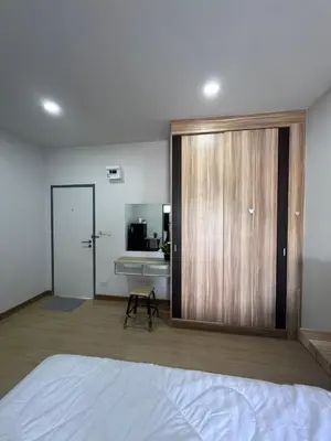 a bedroom with a large wooden door with a bathroom at Nub-Nueng place นับหนึ่ง เพลส in Ban Bo Han