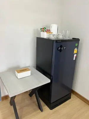 a small black refrigerator next to a table at Nub-Nueng place นับหนึ่ง เพลส in Ban Bo Han
