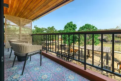 a screened in porch with a table and a chair at Niran Farm in Koh Lone