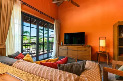 a living room with a couch and a television at Niran Farm in Koh Lone