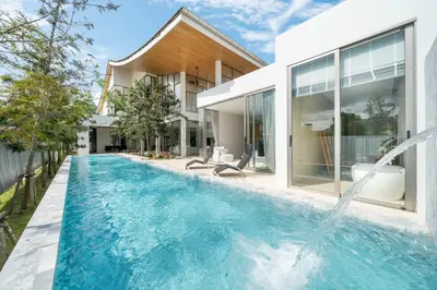 a swimming pool in the backyard of a house at Modern Masterpiece with Tropical Flair! 5BR Villa Trinity C4 in Bang Tao Beach