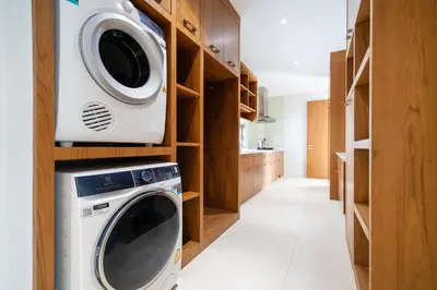 a kitchen with a washing machine and a microwave at Modern Masterpiece with Tropical Flair! 5BR Villa Trinity C4 in Bang Tao Beach