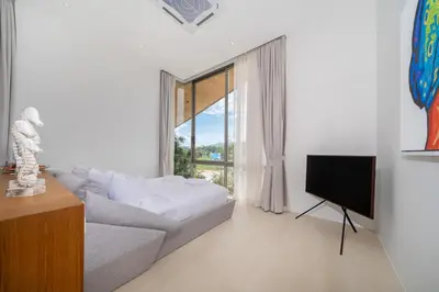 a living room with a couch and a television at Modern Masterpiece with Tropical Flair! 5BR Villa Trinity C4 in Bang Tao Beach