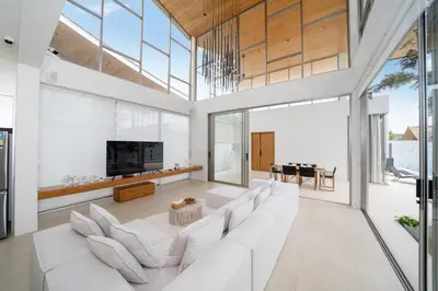 a living room with white furniture and large windows at Modern Masterpiece with Tropical Flair! 5BR Villa Trinity C4 in Bang Tao Beach