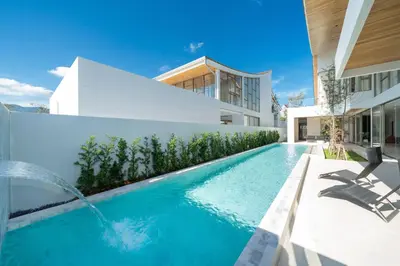 a swimming pool in the backyard of a house at Trendy & Minimalist Design 5BR Pool Villa Trinity C1 in Bang Tao Beach